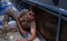 Female Soldier Looking At Camera While Lying On Floor Of Contemporary Military Transport