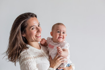 portrait of a beautiful baby girl and her mother at home. Family concept indoors. Daytime and lifestyle