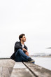 © Westend61 - Denmark, Copenhagen, young man sitting at the waterfront