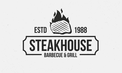 Wall Mural - Steakhouse retro logo. Steak with fire flame. Barbecue restaurant logo, emblem, poster. Vintage design. BBQ Vector template logo.