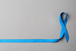 © New Africa - Blue ribbon on color background, top view with space for text. Colon cancer awareness concept