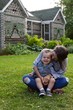 © Bigbambi.ca - Young mother and toddler son sitting in grass during summer smiling and laughing