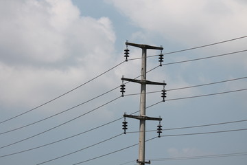 Power line support. Electric wires on a blue sky background. High-voltage lines in the modern city.