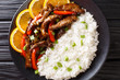 Asian stir fry beef with bell pepper in soybean orange sauce served with rice close-up on a plate. horizontal top view