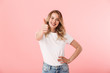 © Drobot Dean - Happy young blonde woman posing isolated over pink wall background showing thumbs up gesture.