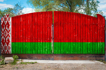 Wall Mural - Close-up of the national flag of Belorussia on a wooden gate at the entrance to the closed territory on a summer day. The concept of storage of goods, entry to a closed area, tourism in Belarus