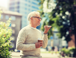 Poster - technology, senior people, lifestyle and communication concept - happy old man using voice command recorder or calling on smartphone outdoors