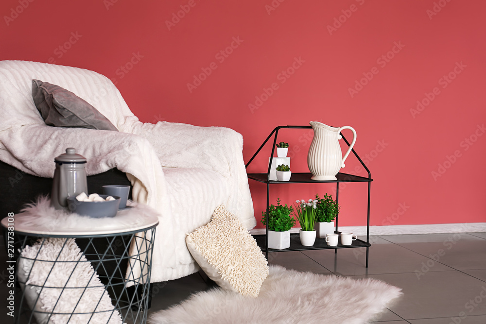 Soft armchair with tables in interior of room