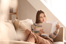 Beautiful Young Woman Reading Book At Home