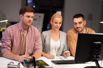 Canvas Print - business, deadline and technology concept - coworkers with computer working late at night office