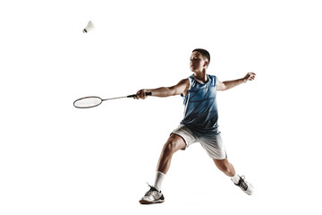 Little boy playing badminton isolated on white studio background. Young male model in sportwear and sneakers with the racket in action, motion in game. Concept of sport, movement, healthy lifestyle.