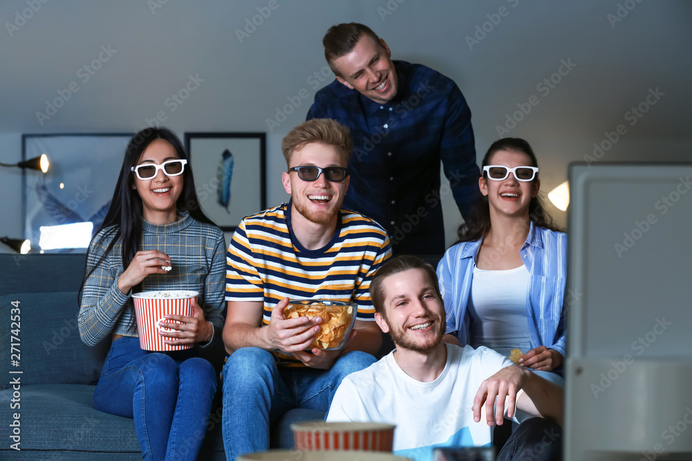 Friends watching TV at home in evening
