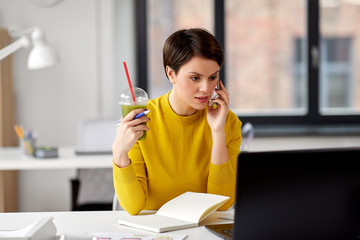 Wall Mural - business, technology and people concept - woman with smoothie and notebook calling on smartphone at office