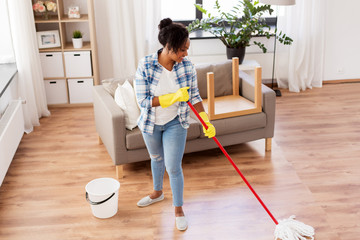 Sticker - housework and housekeeping concept - african american woman or housewife with mop cleaning floor at home