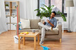 © Syda Productions - household and time management concept - smiling indian man making to do list in notebook after home cleaning