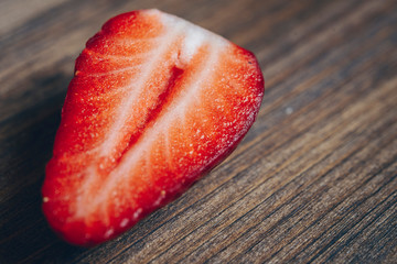 half fresh strawberry on a wooden table