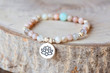 Mineral stone sun stone and lotus pendant bead bracelet on natural wooden background
