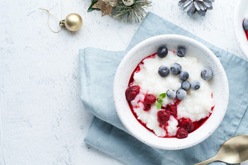 Christmas food, Vegan Coconut Rice Pudding, top view, copy space. Healthy diet breakfast with berries, scandinavian minimalism