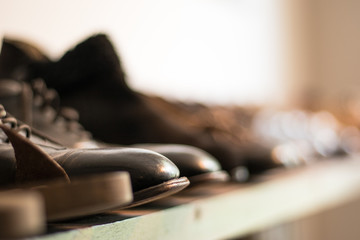 A row of old black leather boots in a cobbler.