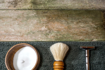 Retro safety razor, shaving brush and lather in bowl. Old-school wet shaving in rustic wooden table, with copy space.