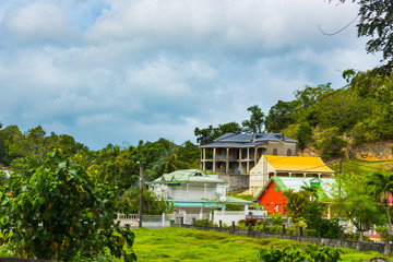 Wall Mural - Colorful houses under a cloudy sky in Guadeloupe countryside