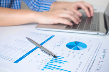 Poster - Close-up of the financial graph of a business worker working on a laptop on a modern white desk.