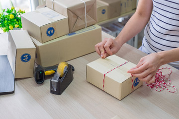 Woman, Start up small business. Owner packing cardboard box at workplace. Prepare parcel packing box of product for deliver to customer. Online selling, e-commerce, shipping concept.