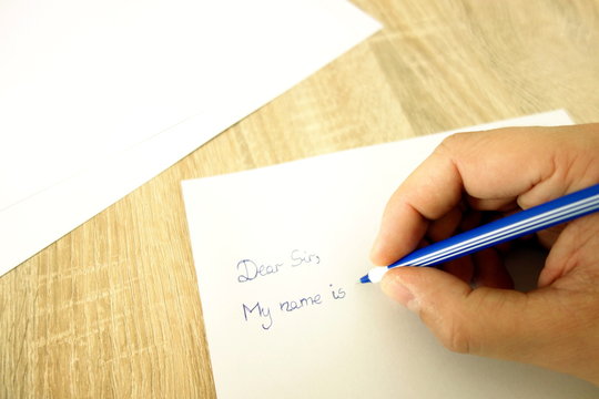 Male hand with pen writing a letter or application