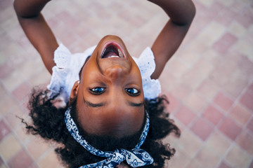 Cute mixed race girl having fun at street. Child innocence concept.