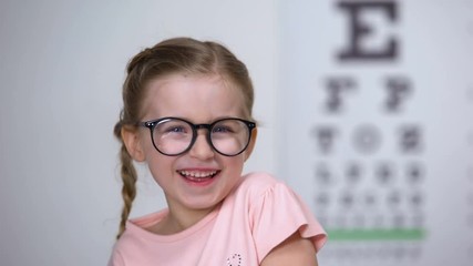 Wall Mural - Joyous little girl in eyeglasses laughing, positive vision treatment results