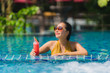 © siraphol - Portrait beautiful young asian woman leisure relax smile with watermelon juice around swimming pool in hotel resort