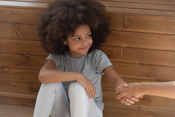 Happy small kid girl orphan holding hand of foster parent