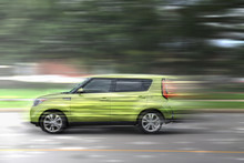 A Green Car At High Speed Rides Along The Road, Speed In Motion