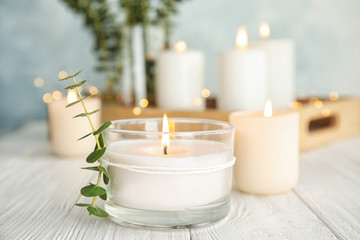 Poster - Burning aromatic candle and eucalyptus branch on table