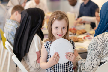 Wall Mural - cute little girl enjoying iftar dinner with family