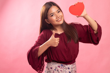 Asian woman thumbs up with red heart.