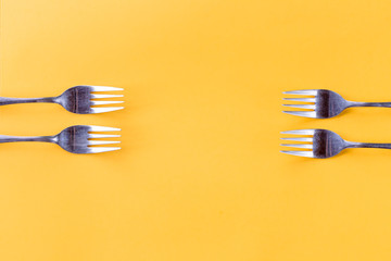 Wall Mural - Border frame of forks, set isolated on yellow background.Frame of the Cutlery forks. Chef Recommends, kitchen utensils and tablecloth concept. Menu for cafe or restaurant. Copy space