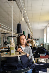 Wall Mural - close up photo of a young woman working with linking machine for knitting in textile industry