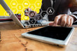 © NINENII - businessman working with tablet and modern computers and business strategy icons in the morning.