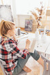 © alfa27 - young female student sitting at the table with a pencil in her hand and writing a poem in the room with modern interior .close up back view photo.