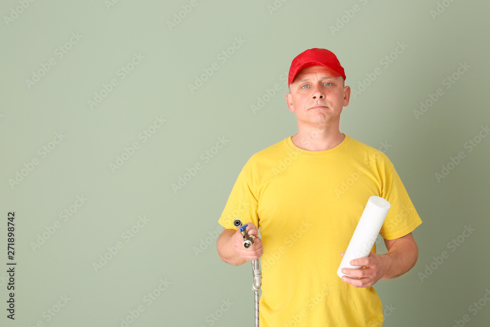 Handsome plumber on color background