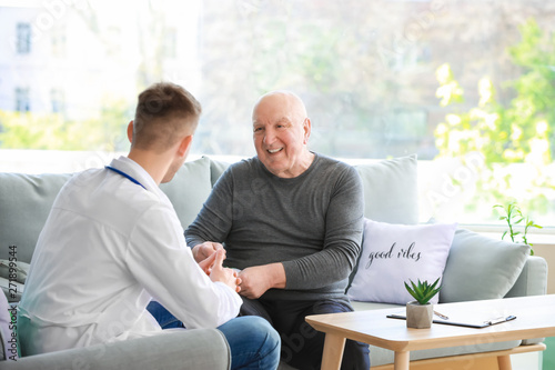 Fotografía Doctor examining senior man in nursing home