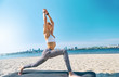 © vitaliymateha - Outdoors portrait of young slim athletic woman standing in yoga asana with raised hands on the city and blue sky background. young pretty fitness lady mixed race of Asian Caucasian ethnicity outdoors