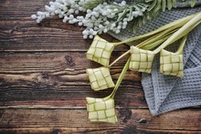 Ketupat (Rice Dumpling) On Wooden Background. Ketupat Is A Natural Rice Casing Made From Young Coconut Leaves For Cooking Rice During Eid Mubarak, Fitri 