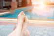 woman feet resting relaxing beside swimming pool.