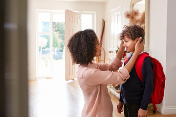 Wall Mural - Single Mother At Home Getting Son Wearing Uniform Ready For First Day Of School