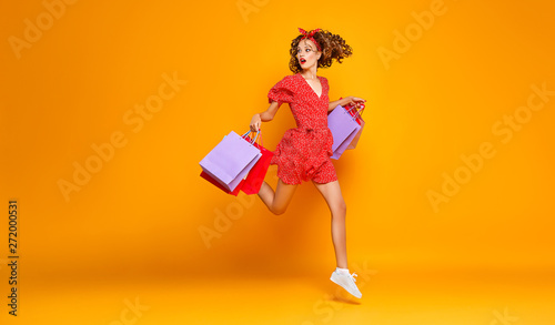 Cuadros en Lienzo concept of shopping purchases and sales of happy young girl with packages on ye