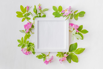 Mockup square white frame with pink flowers on a white background