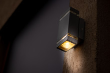 Cubical Looking Lantern Placed On The Exterior Of A Building During Night Time With Copy Space – Modern Electrical Equipment For Illumination