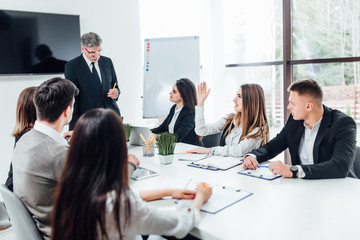 Wall Mural - Boss  businessman holding papers hands and smiling.Young team of coworkers making great business discussion in modern coworking office.